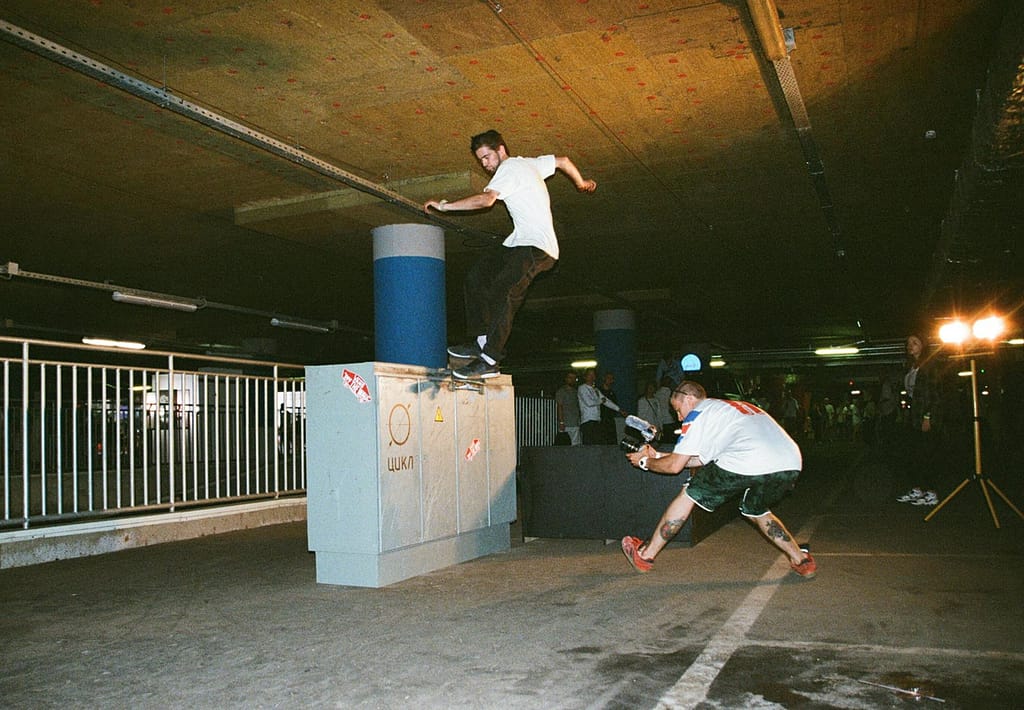 Dynamic shot of a skateboarder performing a trick in a Moscow parking garage, emphasizing urban sports.